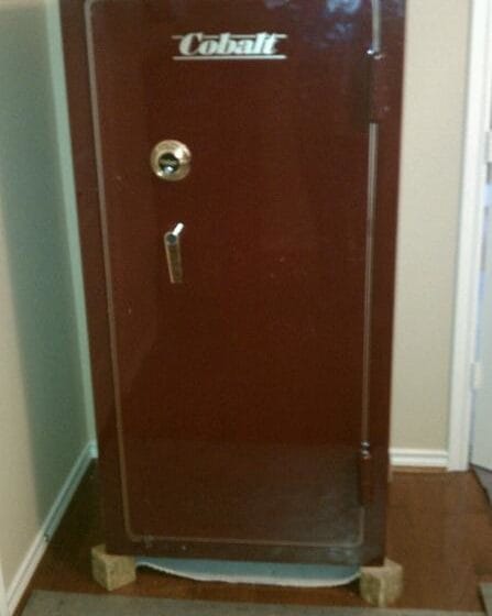 Cobalt gun safe sitting on blocks ready to be lowered onto a small piece of carpet underneath to protect floor